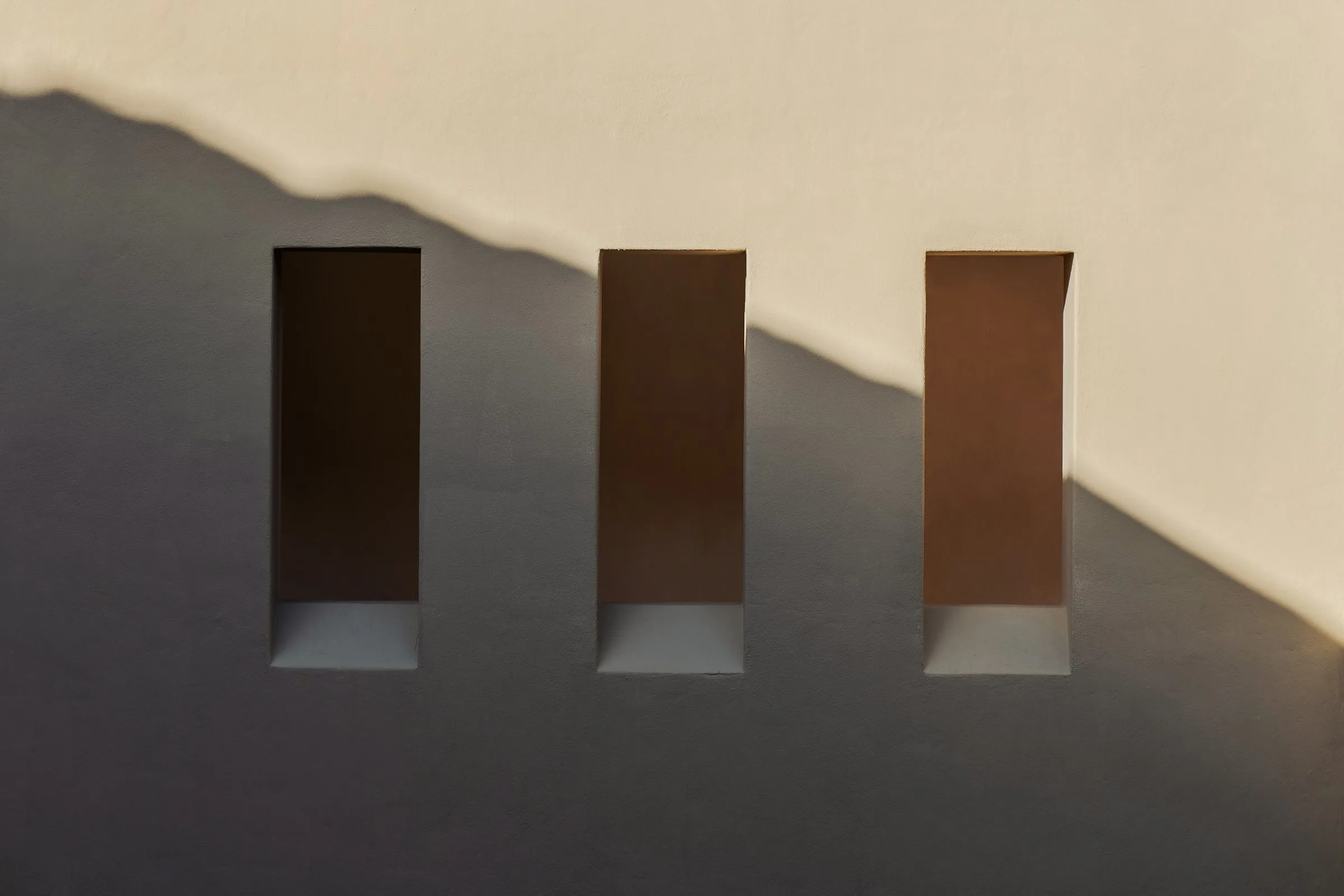 Warm wall with three windows in soft afternoon light